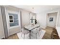 Bright dining room with a stylish chandelier and seating for six at 332 Cottage Hl, Knightdale, NC 27604