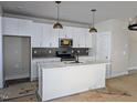 Bright kitchen featuring white cabinetry, a functional island, and stainless steel appliances at 332 Cottage Hl, Knightdale, NC 27604