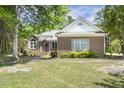 Well-maintained brick home with manicured lawn and mature trees on a sunny day at 3404 Apple Meadow Dr, Fuquay Varina, NC 27526