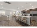 Open-concept kitchen with granite countertops, stainless steel appliances, island with seating, and hardwood floors at 353 Bridle Brook Way, Fuquay Varina, NC 27526