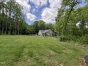 Expansive backyard with lush green grass, mature trees, providing a private and serene outdoor space at 4072 Mackenzie Dr, Haw River, NC 27258