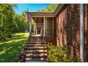 Inviting front porch with brick steps, black railings, and decorative plants at 4072 Mackenzie Dr, Haw River, NC 27258