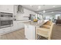 Modern kitchen with stainless appliances, a large island with bar seating, and hardwood floors at 412 Gaston Park Ln # 200, Wake Forest, NC 27587
