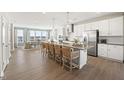 Open kitchen boasts a large island with bar seating, stainless appliances, and hardwood floors at 412 Gaston Park Ln # 200, Wake Forest, NC 27587