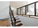 View of a modern staircase and decorative wrought iron railing with an open-concept floor plan at 4205 Woodlawn Dr, Raleigh, NC 27616