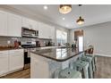 Modern kitchen features a large granite island, stainless steel appliances, and white cabinetry at 636 Ginger Mint Cir, Knightdale, NC 27545