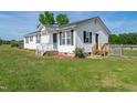 Beautiful home with white siding, black shutters, green grass, and a cozy front porch at 640 Short Journey Rd, Smithfield, NC 27577