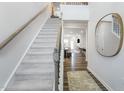 Inviting entryway with a staircase, hardwood floors, a stylish round mirror, and a view into the spacious living area at 740 Swim Cave Ln, Wendell, NC 27591