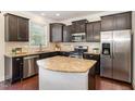 Modern kitchen featuring granite countertops, stainless steel appliances, and a center island at 7508 Channery Way, Raleigh, NC 27616