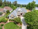 Aerial view of a beautiful home with a well-manicured lawn and a golf course in the background at 77 Ruffed Grouse, Chapel Hill, NC 27517