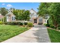 Attractive two-story home with stone accents, a well-kept lawn, and a driveway leading to the entrance at 77 Ruffed Grouse, Chapel Hill, NC 27517