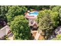 Aerial view of a private residence with a pool surrounded by lush greenery and mature trees at 7901 Farnham Ct, Raleigh, NC 27615