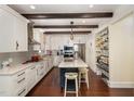 Modern kitchen with white cabinets, stainless steel appliances, island with seating, and hardwood floors at 7901 Farnham Ct, Raleigh, NC 27615
