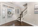 Elegant home foyer featuring hardwood floors, staircase, and glass-paneled front door, providing a welcoming entrance at 808 Buckner Ct, Fuquay Varina, NC 27526