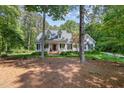 Beautiful white house with a welcoming front porch framed by mature trees and a well-manicured lawn at 8304 Epping Forest Way, Wake Forest, NC 27587