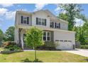 Two-story home with gray siding, black shutters, stone accents, and a well-manicured front lawn at 8616 Deep Elm Dr, Wake Forest, NC 27587
