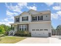 Charming two-story home with gray siding, black shutters, stone accents, and a well-manicured front lawn at 8616 Deep Elm Dr, Wake Forest, NC 27587