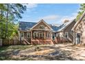 Spacious backyard featuring a wooden deck, a fire pit area, and mature trees for privacy at 100 Bradborne Cir, Clayton, NC 27520