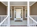 Inviting front porch with classic columns and sidelight windows framing the front door at 100 Bradborne Cir, Clayton, NC 27520