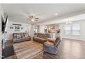Open-concept living room flowing into the kitchen with a fireplace, ceiling fan and wood floors at 104 Lingonberry Dr, Holly Springs, NC 27540