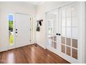 Bright entryway with wood floors, shiplap accent wall, and glass paned french doors leading to a cozy living space at 104 Ludstone Ct, Cary, NC 27513