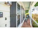 Cozy front porch featuring brick flooring, black shutters, and seating for relaxing, creating an inviting outdoor space at 104 Ludstone Ct, Cary, NC 27513