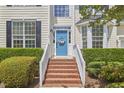 Inviting front entrance with brick steps, white railings, and a cheerful blue front door at 109 Hogan Glen Ct, Chapel Hill, NC 27516
