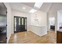 Bright entryway with a skylight, hardwood floors, and black double doors at 109 Lochview Dr, Cary, NC 27518