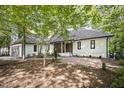 Single-story home featuring a tile roof, a brick front patio, and lush surrounding trees at 109 Lochview Dr, Cary, NC 27518