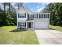 Charming two-story home with a manicured lawn and a two-car garage at 11 Mamie Ferguson Dr, Lillington, NC 27546