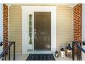 Stylish brown front door with sidelight and matte providing an inviting entryway ambiance at 111 Florians Dr, Holly Springs, NC 27540