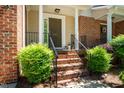 Inviting brick front porch with elegant columns and manicured shrubs enhancing the entryway appeal at 111 Florians Dr, Holly Springs, NC 27540