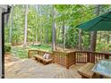 Relaxing back deck with bench seating, outdoor table, and serene backyard views at 112 Parkspring Ct, Cary, NC 27519