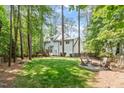 Beautiful backyard featuring a lush lawn, fire pit, and view of the home's exterior at 112 Parkspring Ct, Cary, NC 27519