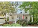 Charming front exterior with a welcoming porch, an American flag, and beautiful landscaping at 112 Parkspring Ct, Cary, NC 27519