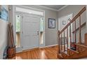 Bright foyer with a white front door, hardwood floors, staircase with wood railing, and decorative accents at 120 Foley Dr, Garner, NC 27529