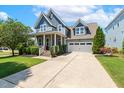 Beautiful two-story home with a spacious driveway and an attached garage, surrounded by green lawns and landscaping at 120 Mearleaf Pl, Holly Springs, NC 27540