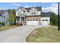 Beautiful two-story home with stone details, a three-car garage, and an expansive, well-kept lawn at 1309 Magnolia Gln Cir, Wake Forest, NC 27587