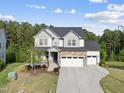 Lovely two-story home boasting a three-car garage and manicured lawn under a bright, sunny sky at 1309 Magnolia Gln Cir, Wake Forest, NC 27587