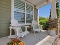 Relaxing front porch featuring Adirondack chairs, side table, and decorative flower accents at 1701 Bodwin Ln, Apex, NC 27502