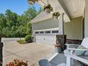 View of a two car garage with adjacent seating on a decorative front porch at 1701 Bodwin Ln, Apex, NC 27502
