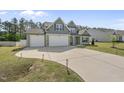 Home's exterior features a spacious driveway, well-manicured lawn, and inviting curb appeal at 178 Ashpole Trl, Clayton, NC 27520