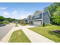 A two-story home displaying the blue siding, landscaping, driveway, and attached garage at 1813 Lost Creek Ct, Apex, NC 27539