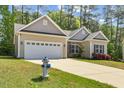 Charming home with white garage door, stone accents and a manicured lawn, complemented by a blue fire hydrant at 217 Griffis Dr, Stem, NC 27581