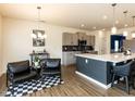 Open concept kitchen featuring stainless steel appliances, gray cabinets, pendant lighting, and eat in bar seating at 218 E Tecoma Ln, Clayton, NC 27520