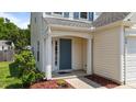 Inviting front entrance with a blue door, decorative shrubbery, and attractive landscaping at 228 Honeywell Way, Fuquay Varina, NC 27526