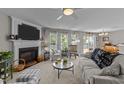 Cozy living room featuring a fireplace, plush seating, and large windows for ample natural light at 228 Honeywell Way, Fuquay Varina, NC 27526