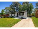 Exterior view of a freshly painted home with a long driveway and manicured lawn at 2311 Wintergreen Pl, Durham, NC 27707