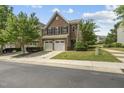 Charming brick home with attached garage, surrounded by a lush green lawn and mature trees at 245 Kylemore Cir, Cary, NC 27513