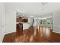 Open concept living space with hardwood floors, and kitchen with granite counters at 245 Kylemore Cir, Cary, NC 27513